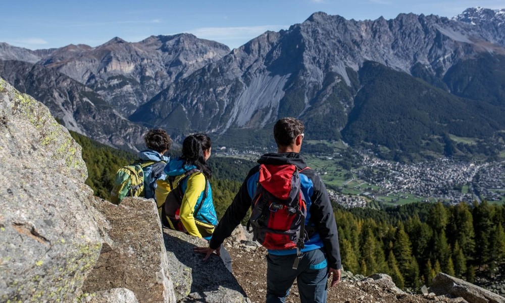Escursionisti con zaini osservano un panorama montano mozzafiato.